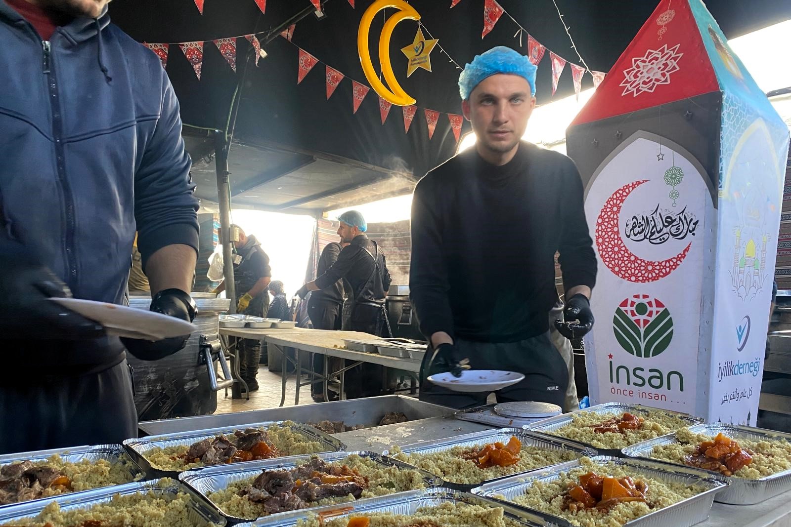 الشاب عدنان أبو لبدة يعمل في مطبخه المتواضع لإعداد طعام الإفطار للنازحين، في منطقة مواصي خان يونس جنوب قطاع غزة (تصوير: محمد دهمان/وفا)